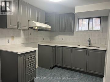 Toronto (Woburn) apartment for rent - A kitchen with grey cabinets and a white counter top.