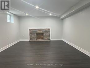 Toronto (Woburn) apartment for rent - A room with a stone fireplace and wooden floors.