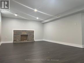 Toronto (Woburn) apartment for rent - A room with a stone fireplace and wood flooring.