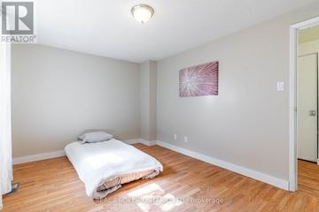 Kitchener multi-family for rent - A bedroom with a bed and a painting on the wall.