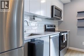 Brantford condo for rent - A modern kitchen with stainless steel appliances and white cabinets.