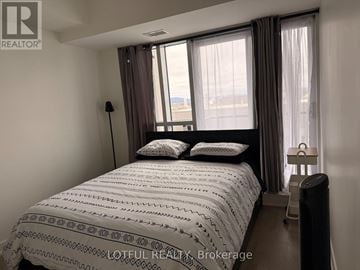 Ottawa condo for rent - A bedroom with a large bed and a window with curtains.