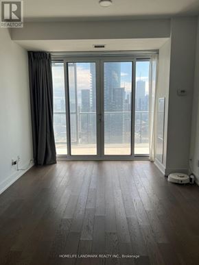 Toronto (Bay Street Corridor) condo for rent - A room with a large window and wooden flooring.