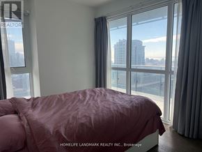 Toronto (Bay Street Corridor) condo for rent - A bedroom with a large bed and a view of the city.
