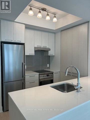 Toronto (Forest Hill South) house for rent - A kitchen with a stainless steel refrigerator and a sink with a faucet.