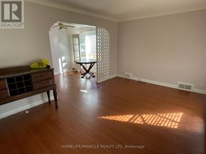 Toronto (Kennedy Park) apartment for rent - A room with wooden floors and a table with a yellow cloth on it.