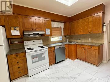 Toronto (Kennedy Park) apartment for rent - A kitchen with wooden cabinets and a white stove top oven.