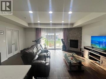 Windsor townhouse for rent - A living room with a black leather couch and a flat screen TV.