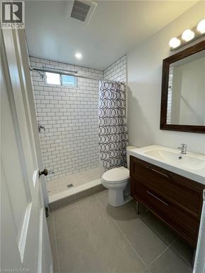 Hamilton apartment for rent - A bathroom with a toilet, sink, and shower.