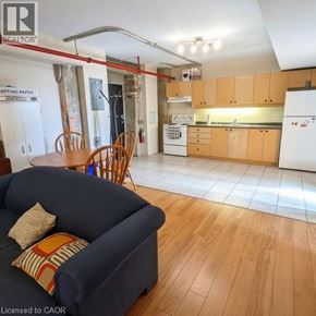 Waterloo condo for rent - A living room with a blue couch and a kitchen in the background.