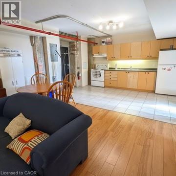 Waterloo condo for rent - A living room with a blue couch and a kitchen in the background.