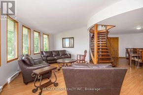 Adjala-Tosorontio apartment for rent - A living room with a spiral staircase and leather furniture.
