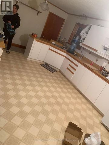 Cambridge apartment for rent - A woman is standing in a kitchen with a checkered floor.