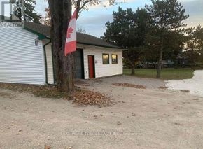 Cambridge apartment for rent - A small white building with a red door and a Canadian flag on a tree.