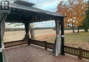 Cambridge apartment for rent - A gazebo with a black roof and grey curtains is situated on a wooden deck.