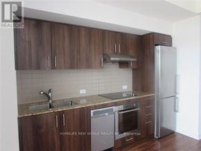 Toronto (Agincourt South-Malvern West) condo for rent - A kitchen with wooden cabinets and a refrigerator.