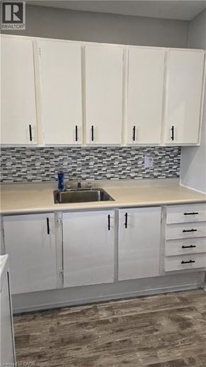 Hamilton condo for rent - A kitchen with white cabinets and a sink.