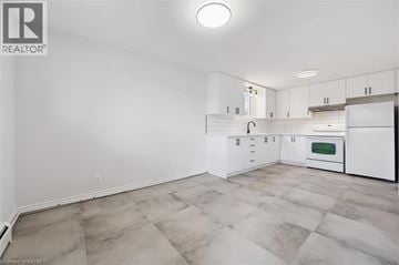 Kitchener apartment for rent - A kitchen with white cabinets and a tiled floor.