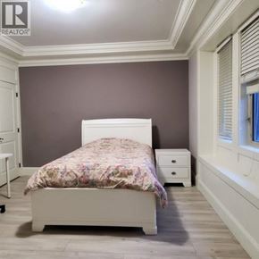 Richmond apartment for rent - A bedroom with a bed, nightstand, and a window with blinds.