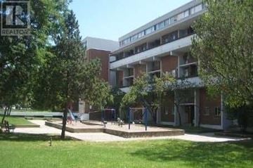 Toronto (Flemingdon Park) townhouse for rent - A large building with a lawn in front of it.