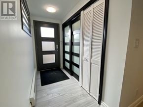 Toronto (Weston-Pellam Park) fourplex for rent - A hallway with a black door and white walls.