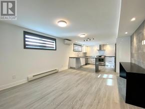 Toronto (Weston-Pellam Park) fourplex for rent - A spacious kitchen with a black countertop and a window with blinds.