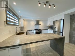 Toronto (Weston-Pellam Park) fourplex for rent - A modern kitchen with a large island in the center.