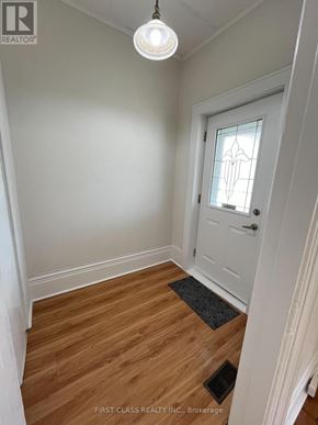 London East (East G) apartment for rent - A hallway with a white door and a light hanging from the ceiling.