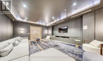 Toronto (Regent Park) condo for rent - A well-lit, modern living room with a grey sofa and a television.