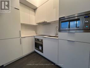 Toronto (Newtonbrook East) condo for rent - A modern kitchen with white cabinets and a stainless steel oven.