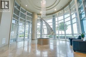 Windsor condo for rent - A large, well-lit lobby with a chandelier and a reception desk.