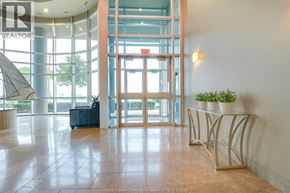 Windsor condo for rent - A reception area with a plant on a table and a chair.