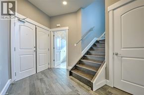 Windsor condo for rent - A hallway with a staircase and white doors.