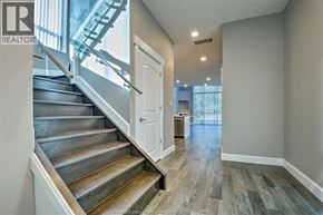 Windsor condo for rent - A staircase with wooden steps and a metal railing leads to a bright room.