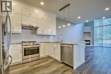 Windsor condo for rent - A kitchen with white cabinets and stainless steel appliances.