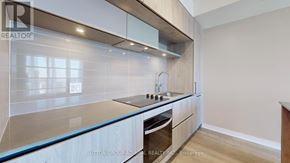 Richmond Hill condo for rent - A modern kitchen with a glass countertop and stainless steel appliances.