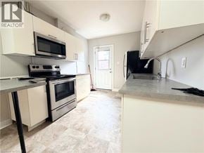Hamilton apartment for rent - A kitchen with a black stove top oven and a black microwave.
