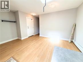 Hamilton apartment for rent - A room with wooden flooring and a white door.