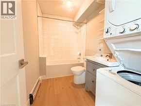 Hamilton apartment for rent - A small bathroom with a toilet, sink, and a washer and dryer.