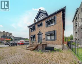 Windsor apartment for rent - A brick house with a black awning and a black fence in front.