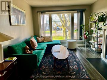 Niagara Falls (Ascot) apartment for rent - A living room with a green couch and a wooden coffee table.