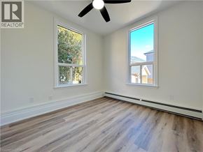 Stoney Creek apartment for rent - A room with a ceiling fan and two windows.