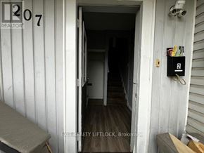 Peterborough (Town Ward 3) multi-family for rent - A white door with a number 207 on it and a sign that says REALTOR.