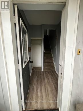 Peterborough (Town Ward 3) multi-family for rent - A hallway with a door on the left and a staircase on the right.