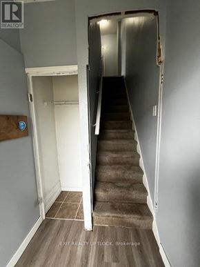 Peterborough (Town Ward 3) multi-family for rent - A stairway leading to a doorway with a sign that says EXIT REALTY LIFTLOCK Brokerage.