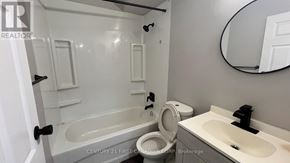 London East (East B) house for rent - A bathroom with a tub, toilet, and sink.