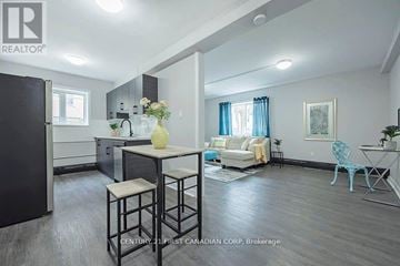 London East (East B) townhouse for rent - A well-lit kitchen and living room with a dining table and chairs.