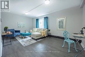 London East (East B) townhouse for rent - A living room with a blue chair and a white couch.
