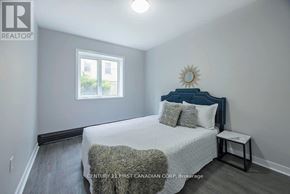 London East (East B) townhouse for rent - A bedroom with a bed, pillows, and a window.