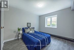 London East (East B) townhouse for rent - Bedroom with a bed, nightstand, and window.